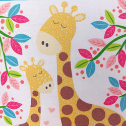 2 giraffes standing side by side surrounded by pink, green and blue leaves