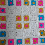 bright granny squares of yellow, gold, blue and cream. the squares are laid out to make a large square blanket