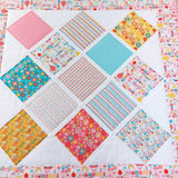 patchwork quilt with images of flowers, bicycles, skates, hot air balloons